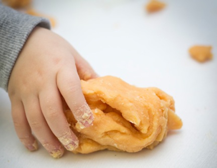 Young child picks up playdough