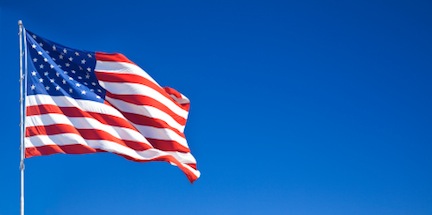 American flag waving in blue sky